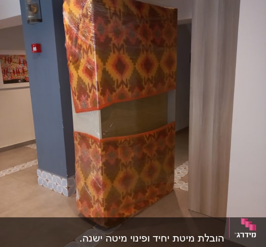 מזרן עטוף בניילון עומד במסדרון